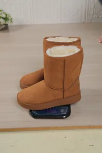 Close-up view of brown suede winter snow boots showing weight on a digital scale