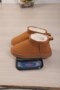 Macro detail showing brown plush-lined mini snow boots weighed on a digital scale at 424g.