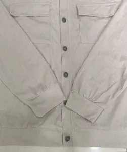 Macro detail of beige corduroy long sleeve shirt with chest pockets and metal buttons