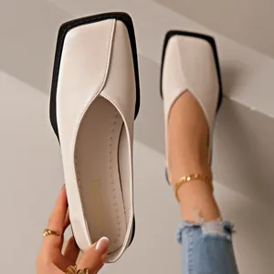 Gros plan sur des mocassins crème à bout carré avec des détails de couture.