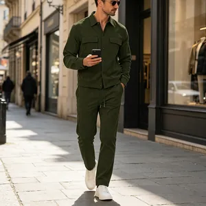 Detailed view of a man walking outdoors wearing a stylish green corduroy casual two-piece set