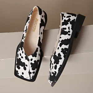 Détail de mocassins à bout carré pour femmes avec un motif imprimé vache tendance.