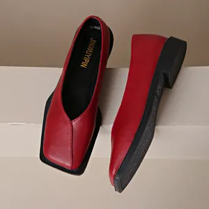Détail rapproché de mocassins élégants en cuir rouge pour femmes à bout carré sur socle