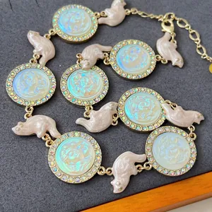 Detail view of a vintage cameo necklace with iridescent resin charms and rhinestones.