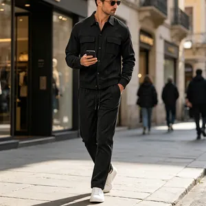 Outdoor full shot of men's black corduroy casual two-piece set showing texture and fit