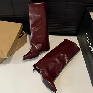 Detail view of wine red fold-over knee-high boots with pointed toe and stiletto heel