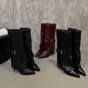 Detail view of stylish pant-leg boots with buckle accents in glossy black and burgundy