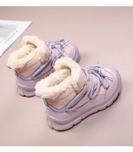 Close-up of warm children's winter snow boots with thick faux fur lining and purple laces.