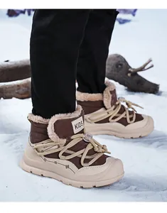 Detailed side view of brown children's winter snow boots on snow, warm fleece lining