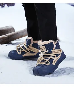 Close-up of kids' blue winter snow boots with thick fur lining in a snowy landscape