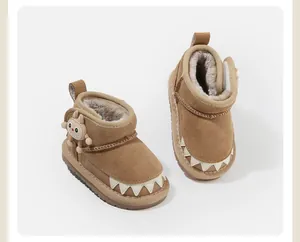 Close-up of cozy brown fleece-lined baby snow boots with cute monster charm