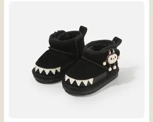 Detail showing the plush lining and monster charm on black toddler winter boots
