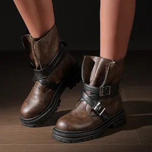 Detaillierte Ansicht der braunen Vintage-Plateaustiefel mit schwarzen Schnallenriemen.
