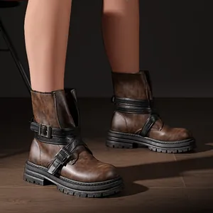 Nahaufnahme von braunen Martin Boots mit stilvollen schwarzen Kreuzschnallenriemen