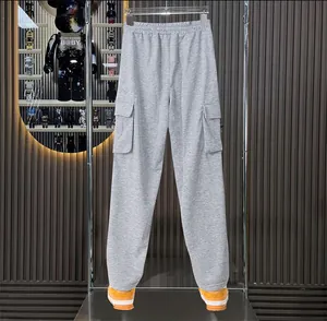 Detail view of grey multi-pocket cargo sweatpants featuring elastic waist and relaxed fit