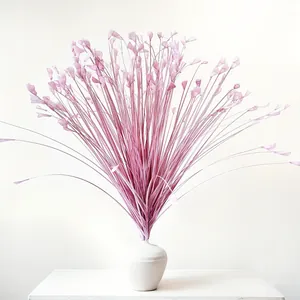 Roze kunstmatig pauwengras arrangement in een witte keramische vaas voor bruiloft decor