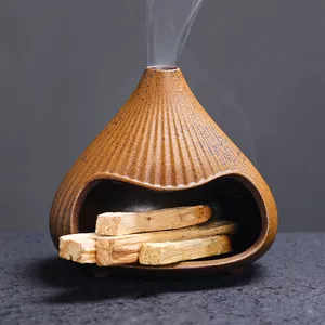 Zen-style Fuji mountain ceramic incense burner for Palo Santo wood with rising smoke.