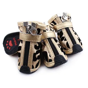 Close-up of leopard print dog shoes with gold trim and functional zipper closure