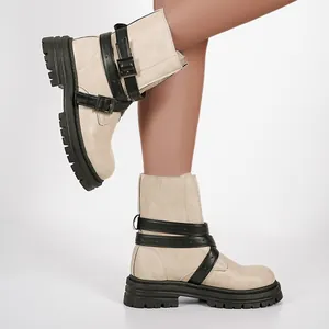 Detailansicht von beigen Plateau-Stiefeletten mit stilvollen schwarzen Schnallen