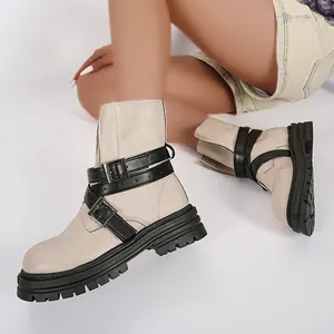 Detailansicht der beigen Plateau-Stiefeletten mit schwarzen Schnallenriemen-Design