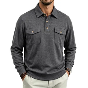Detail of dark grey long-sleeved polo shirt with dual flap chest pockets and buttons.