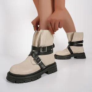 Nahaufnahme von stilvollen beige Damen Stiefeletten mit schwarzen Schnallen und dicker Sohle