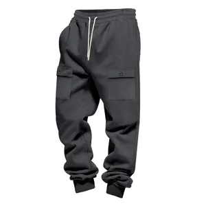 Dettaglio dei pantaloni cargo grigio scuro pesanti con coulisse e grandi tasche.