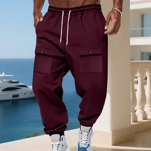 Dettaglio dei pantaloni cargo bordeaux pesanti da uomo in un ambiente costiero aperto