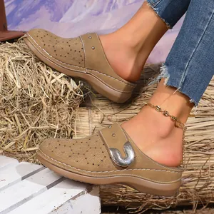 Close-up shot of women's vintage brown platform clogs with a unique floral hollow-out design