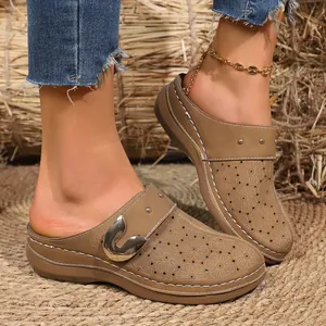 Close-up of French vintage platform mules with laser-cut floral pattern and metal buckle.