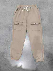 Dettaglio di pantaloni cargo pesanti kaki con coulisse in vita e polsini a costine.