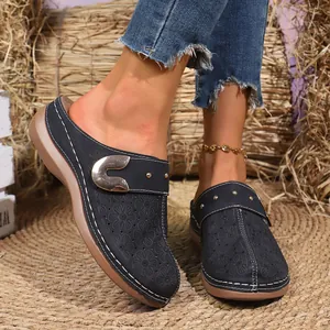 Close-up of vintage hollowed-out pattern and metal buckle on platform clogs for women.