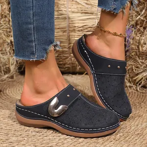 Macro view of navy blue floral cutout clogs featuring a comfortable platform sole.