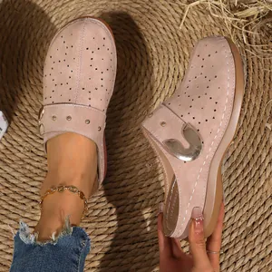 Detailed view of pink French vintage closed-toe platform mules with floral cutouts
