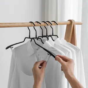 Black non-marking hangers for seamless shoulder support on a wooden rack