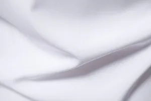 Close-up view showing the smooth texture and soft folds of premium white shirt fabric