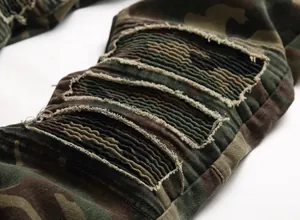 Macro view of distressed moto-style ribbed panels on camouflage cargo jeans for men