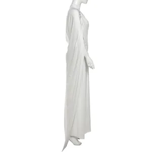 Side view detail of white high-neck pleated top and long skirt set with elegant drapes