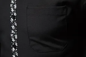 Close-up detail of a black men's casual shirt featuring a floral print placket and pocket.