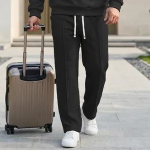 Detail of men's black waffle knit trousers with elastic waist for outdoor travel