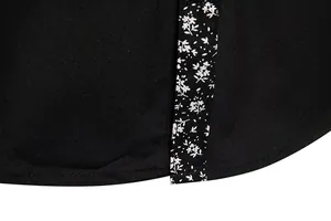 Detailed view of black shirt hem featuring intricate white floral pattern trim