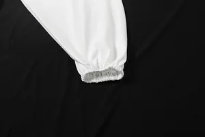 Close-up detail of the elastic shirred cuff on a white elegant long sleeve pleated blouse