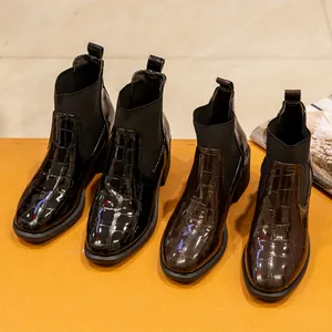 Vista detallada de botines de mujer con estampado de cocodrilo, tacón ancho y elástico lateral.