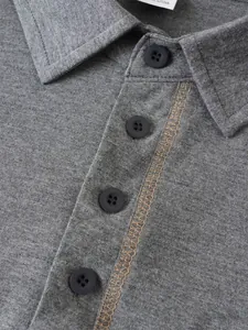 Detail eines grauen Herren-Poloshirts mit schwarzen Knöpfen und Kontrastnähten