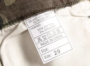 Detailed view of the fabric care label on men's camouflage slim fit cargo jeans