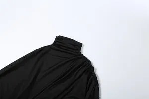 Close-up of black high-neck top featuring elegant ruched shoulder and neck details.