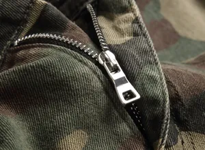 Close-up macro shot of the metal zipper and fabric detail on men's camouflage cargo pants