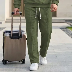 Detailed view of men's olive green waffle-knit leisure pants with elastic waist drawstrings