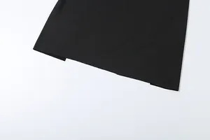 Detailed view of the side slit on a sleek black midi skirt from a chic two-piece set