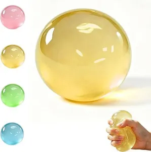 Detail view showing a soft yellow maltose squishy stress ball being squeezed by hand.